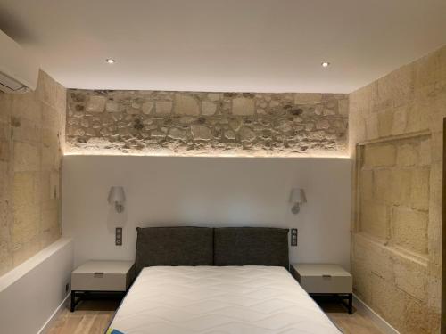 a bedroom with a large bed with two tables at Superbe appartement avec vue in Arles