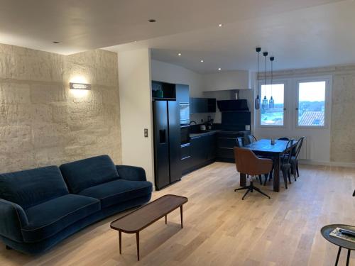 un salon avec un canapé bleu et une table dans l'établissement Superbe appartement avec vue, à Arles