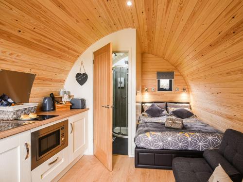 een slaapkamer met een bed in een houten kamer bij Celyn Bach - Uk37083 in Llanwddyn