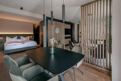 a bedroom with a bed and a table and chairs at La Libella - Suite #5 - la terrazza mit privatem Pool in Merano
