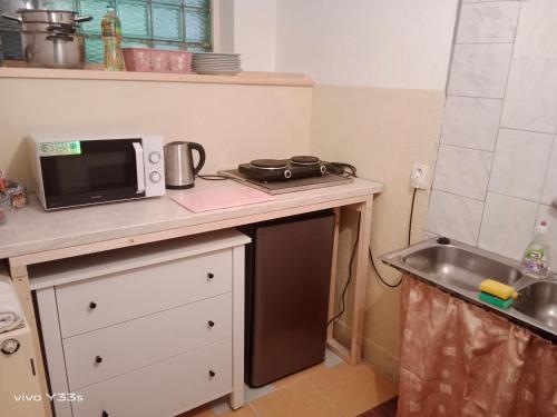a small kitchen with a microwave and a sink at Lucerna in Hřensko