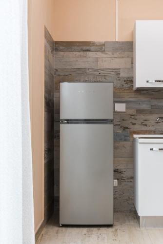a refrigerator in a kitchen with a wooden wall at Relax Ciampino - By Good Time Apartments in Ciampino