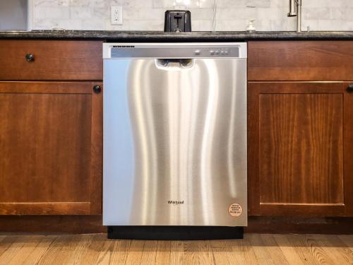 a stainless steel dishwasher in a kitchen with wooden cabinets at Beautiful Wooster Sq. getaway - great neighborhood in New Haven