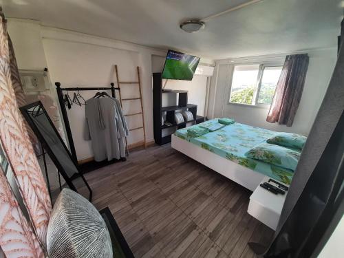 1 dormitorio con cama y ventana en la tête dans les nuages en Basse-Terre
