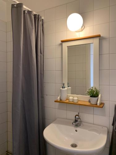 bagno con lavandino e specchio di Stationsterrassen 7, rum 704 a Båstad