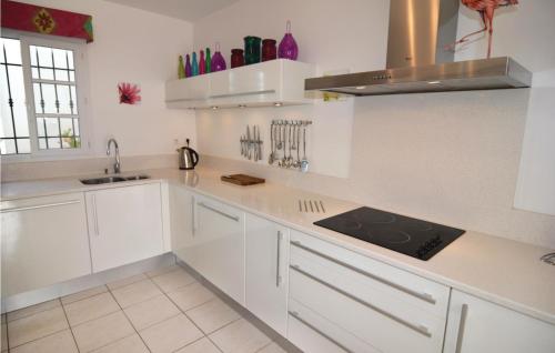 une cuisine blanche avec des armoires blanches et un évier dans l'établissement 3 Bedroom Nice Home In Aigues-Mortes, à Aigues-Mortes