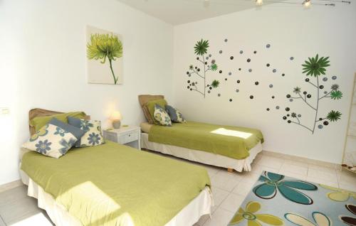 エーグ・モルトにあるGorgeous Home In Aigues-mortes With Wifiのベッドルーム1室(緑のシーツと植物が壁に飾られたベッド2台付)