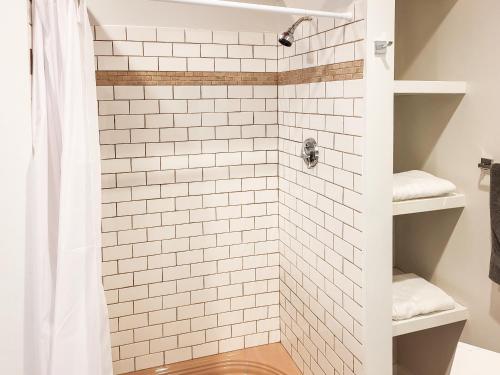 ein Bad mit einer Dusche und weißen Fliesen in der Unterkunft Beautiful Wooster Sq. getaway - great neighborhood in New Haven