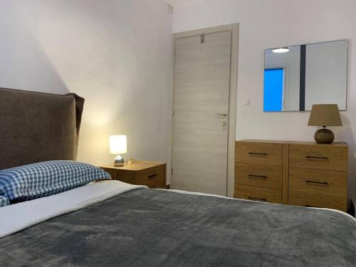 a bedroom with a bed and a dresser and a mirror at Blue Flag Award Winning Ormos Lo Beach: Home 1 in Vrontados