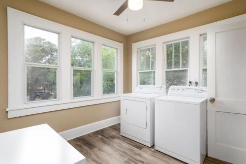 a laundry room with two washing machines and windows at Spacious Beach Getaway Near Downtown #B in St Petersburg