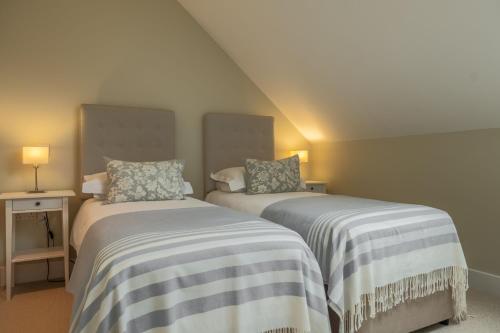 two beds sitting next to each other in a room at 1 Railway Cottages H in Holt