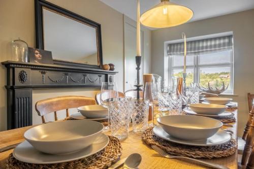 a dining room table with bowls and plates on it at Evergreen in Thornage