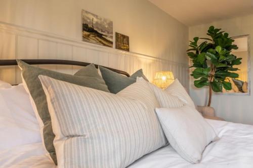 a bed with white sheets and pillows on it at Evergreen in Thornage
