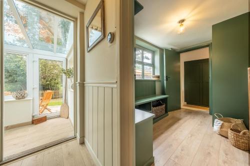 a room with green walls and a large window at Evergreen in Thornage