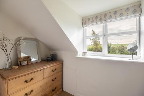 a bedroom with a dresser and a window at Evergreen in Thornage