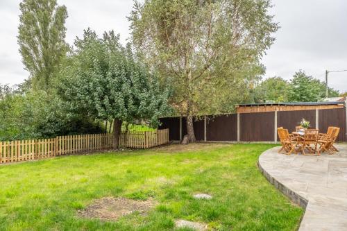 a patio with a table and chairs in a yard at Evergreen in Thornage