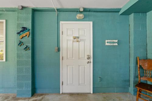 a blue wall with a white door in a room at Turtle Hideaway- Walk to Beach & Pier in Saint Augustine