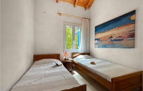 2 camas en una habitación con un cuadro en la pared en Nice Home In Mantineia Messinia With Wifi, en Kitriaí