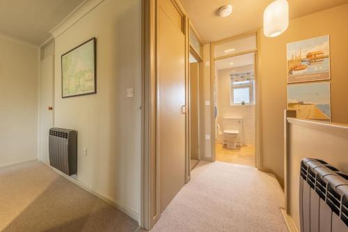 a hallway with a door leading to a bathroom at 12 The Close in Brancaster