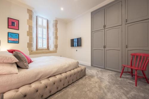 a bedroom with a bed and a red chair at The Chapel in North Elmham