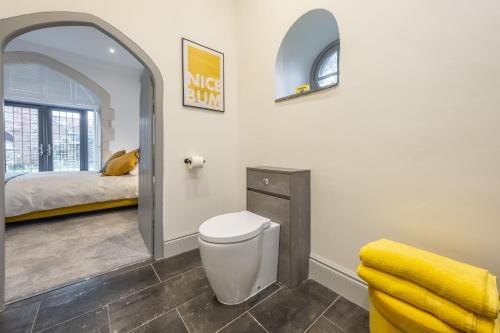 a bathroom with a toilet and a bed in a room at The Chapel in North Elmham