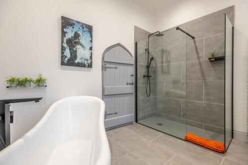 a bathroom with a shower and a bath tub at The Chapel in North Elmham