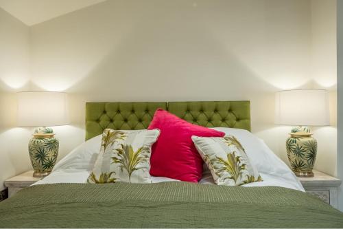 ein Bett mit einem rosa Kissen und zwei Lampen in der Unterkunft The Gardeners Cottage E 