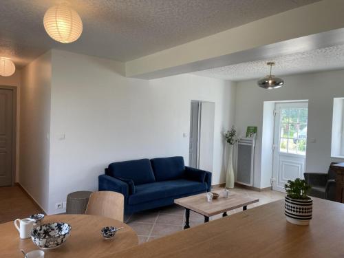 a living room with a blue couch and a table at Maison Confortable avec Grand Jardin, Proche de la N7, Idéale pour Balades et Séjours Détente - FR-1-489-446 in Trévol