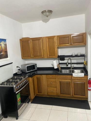una cucina con mobili in legno e un forno a piano cottura di Weekendz- Cozy 2BRD Suite a Port Antonio