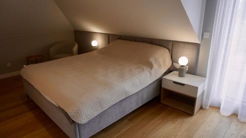 1 dormitorio pequeño con 1 cama y mesita de noche con 2 lámparas en Agroturystyka Ostrowie, en Dąbrowa Grodzieńska-Wieś