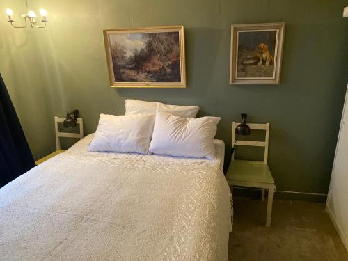 a bedroom with a white bed with two pictures on the wall at Valberg Gjestegård in Valberg