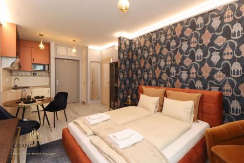 a bedroom with a large bed and a kitchen at Grand Suites Central in Budapest
