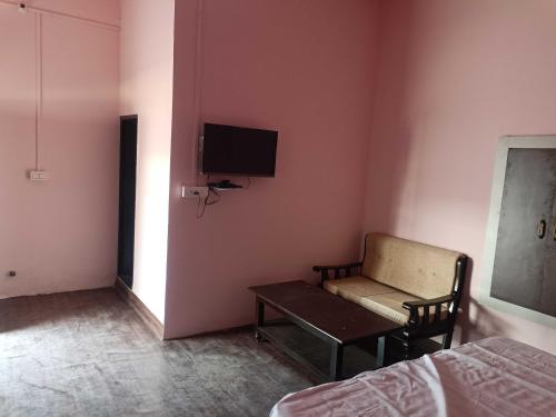 a room with a bed and a couch and a tv at POP 80511J Palki Hotel And Marriage Palace in Singhāna