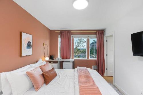 een slaapkamer met een wit bed met kussens en een raam bij Chris's Sweet Suite - 84 Walkscore in Seattle