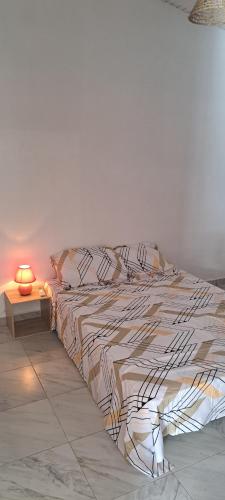 een bed in een kamer met een lamp op een tafel bij Villa tempÔ in Sainte-Rose