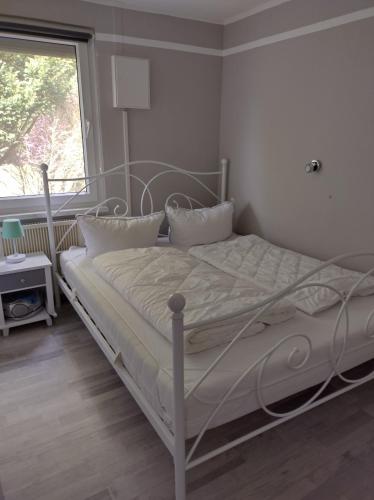 uma cama branca num quarto com uma janela em Ferienhaus Oscar em Ahlbeck