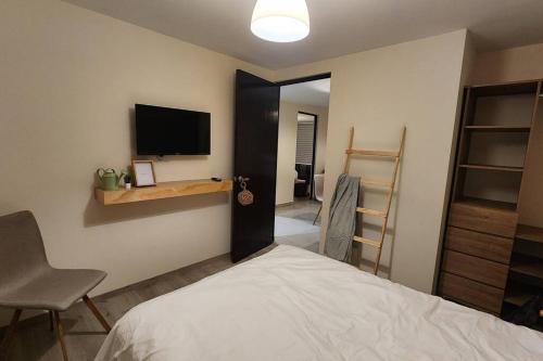 a bedroom with a bed and a tv on the wall at Básico Departamento in Puebla