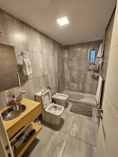 a bathroom with a toilet and a sink and a tub at Departamento amoblado con balcón y cochera en la entrada de escobar in Belén de Escobar