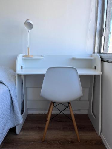 a desk with a white chair and a lamp at Hermoso apartamento en casco histórico con vistas al río in Montevideo