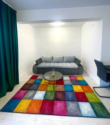 ein Wohnzimmer mit einem Sofa und einem bunten Teppich in der Unterkunft Residence 1 in Ploieşti