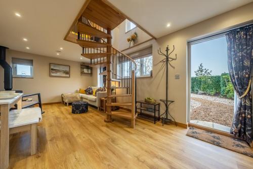 的住宿－Bumblebee Cottage，客厅位于房子内,设有螺旋楼梯