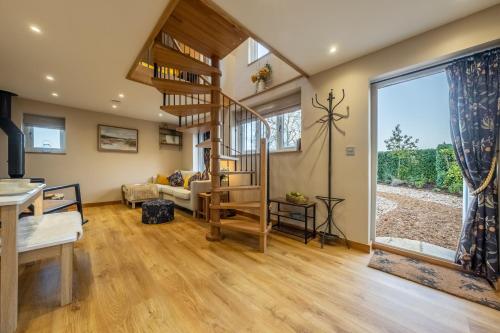 - un salon avec un escalier en colimaçon dans une maison dans l'établissement Bumblebee Cottage, à Barnham