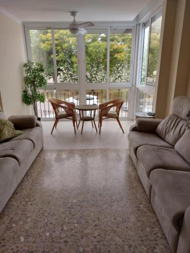 sala de estar con sofá, mesa y sillas en AMPURDAN Bella Vista, en Torre del Mar