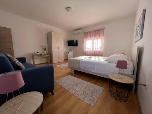 1 dormitorio con 1 cama y 1 sofá azul en Sobe Lea en Sukošan