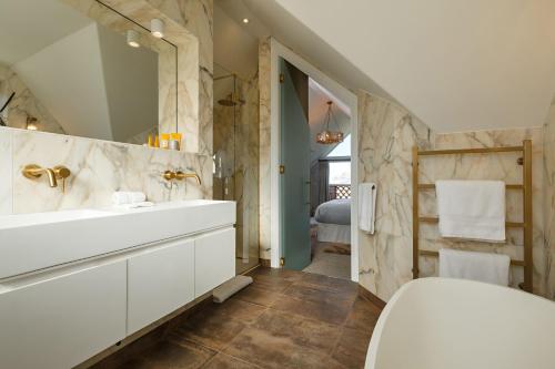 a bathroom with a white sink and a mirror at The Ballroom in Blakeney