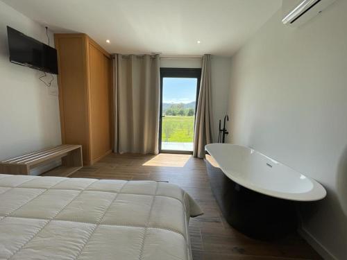 a bedroom with a large bed and a bath tub at Olivo de Reis in Caldas de Reis
