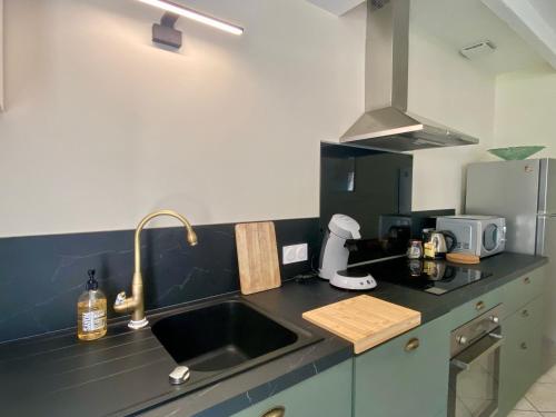 une cuisine avec un évier et un plan de travail dans l'établissement Sur la route des Vins Maison proche Saint Emilion, à Sainte-Terre