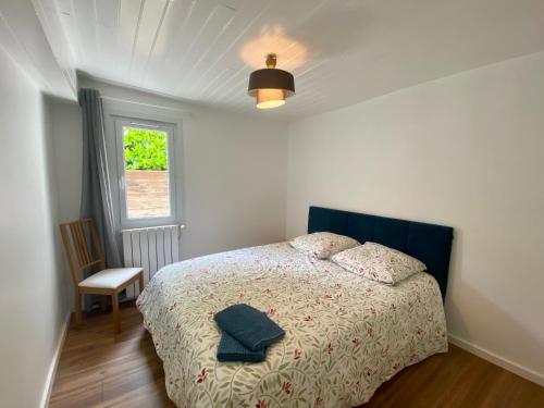 1 dormitorio con 1 cama con cabecero azul y ventana en Sur la route des Vins Maison proche Saint Emilion, en Sainte-Terre
