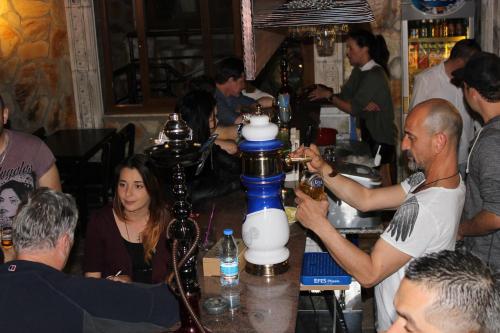 a group of people standing around a bar with a bartender at Atillas Getaway in Selcuk