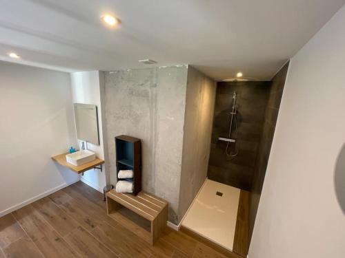 a bathroom with a shower and a bench and a sink at Olivo de Reis in Caldas de Reis